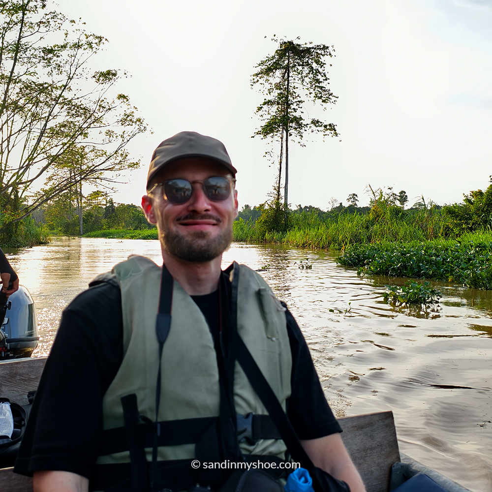 Petteri on a boat during a Kinabatangan River cruise, experiencing a Borneo safari surrounded by jungle.