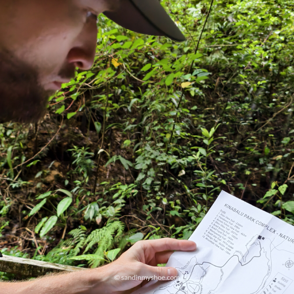 Mereading a map in Kundasang, a scenic stop on a Malaysia 10-day itinerary