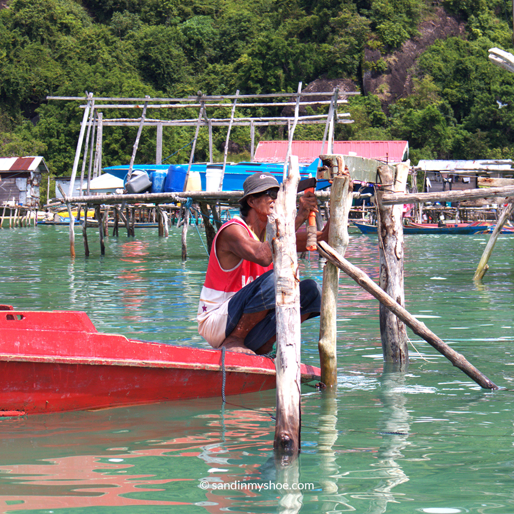 Sea Gypsy Malaysia man building a stilt house above the sea
