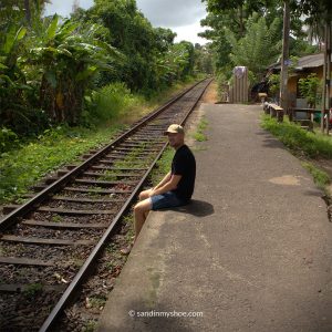 Petteri sitting next to railway tracks in Sri Lanka, pondering whether Colombo or Negombo is the best starting point during a Sri Lanka trip.