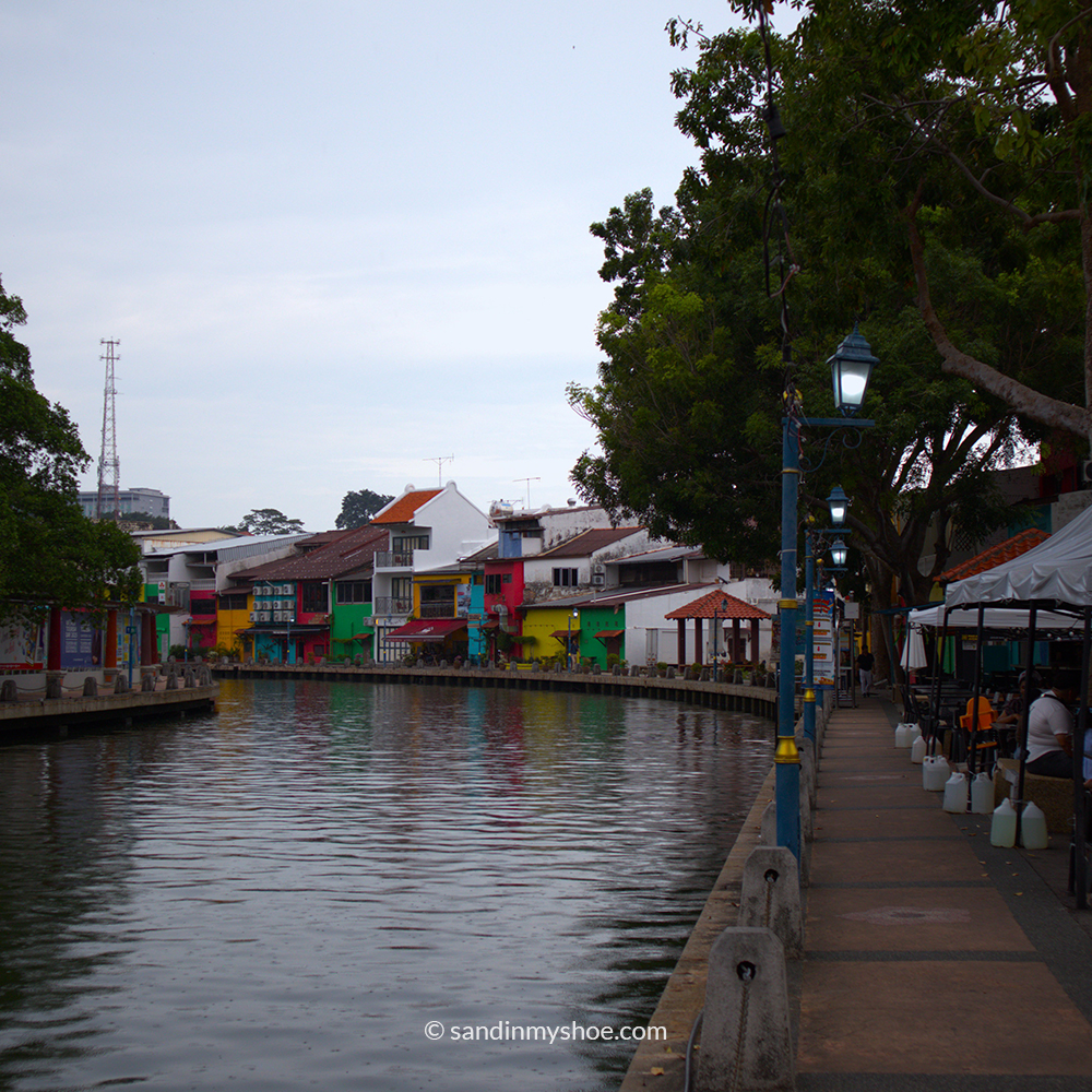 Melaka River with colorful riverside houses reflecting in the water