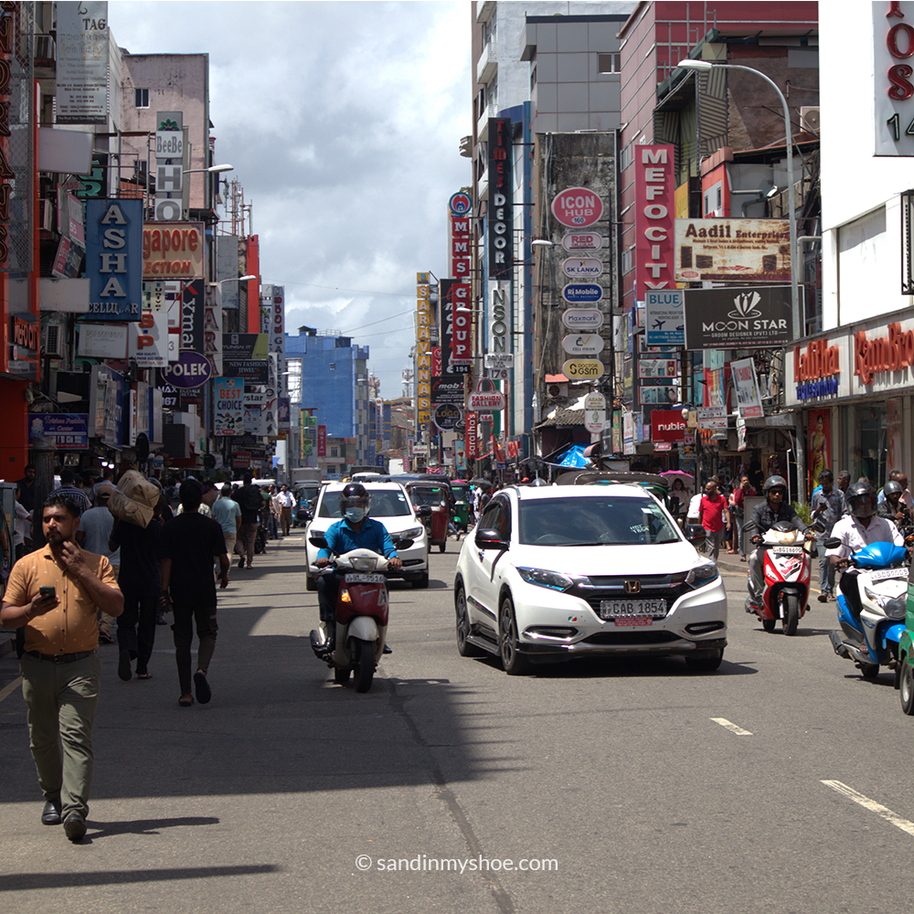 Bustling Sri Lankan traffic scene with tuk tuks and buses, capturing the intensity of driving on a Sri Lanka tuk tuk route.