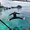Petteri jumping back-first from a boat into crystal-clear waters in Semporna, Malaysia — one of the unforgettable Southeast Asia places to go for island adventures and snorkeling.