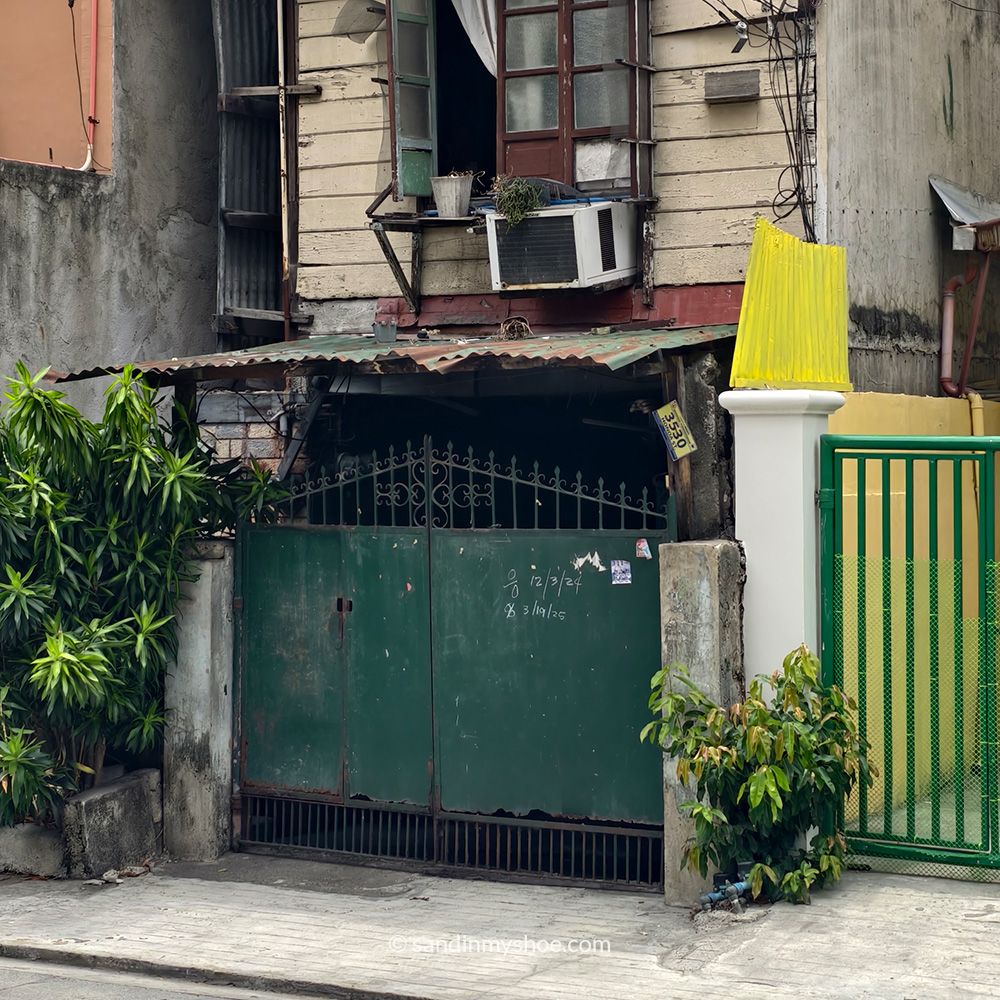 Residential house featuring green metal gate and open window