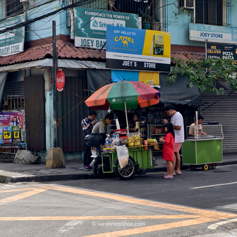 Street vendor selling food on a relaxed Manila sidewalk