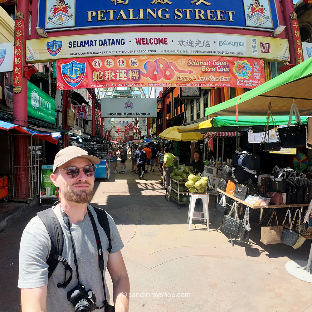 Petteri walking through Petaling Street in Kuala Lumpur’s Chinatown, surrounded by market stalls.