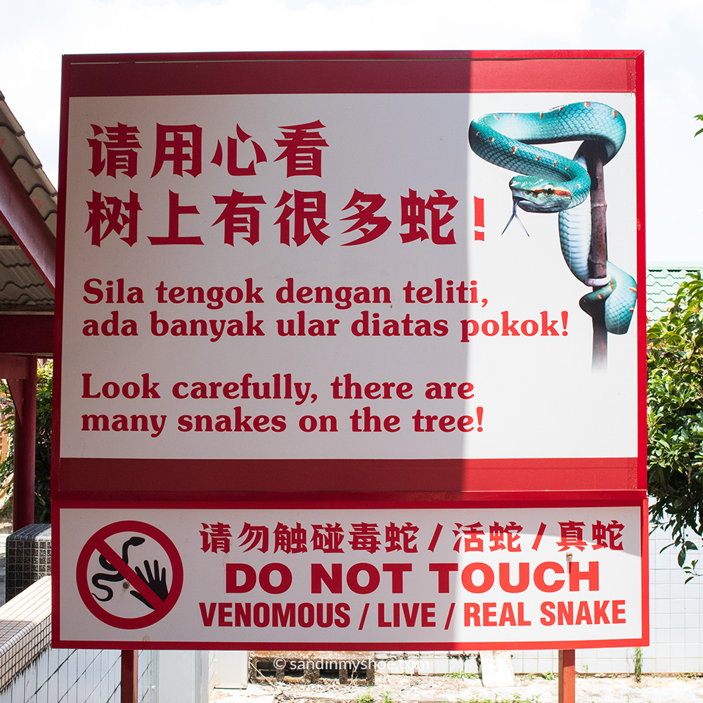 Warning sign at Snake Temple in Penang advising visitors not to touch the snakes for safety reasons.