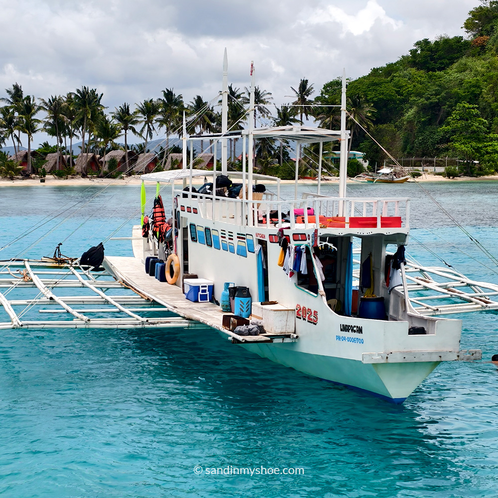 Traditional bangka boat sailing between islands during the Coron–El Nido expedition in the Philippines.