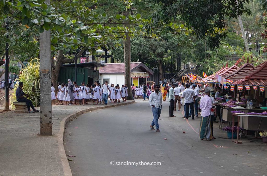 A street next to Lake Kandy. Locals preparing for celebrations of Buddha Day.