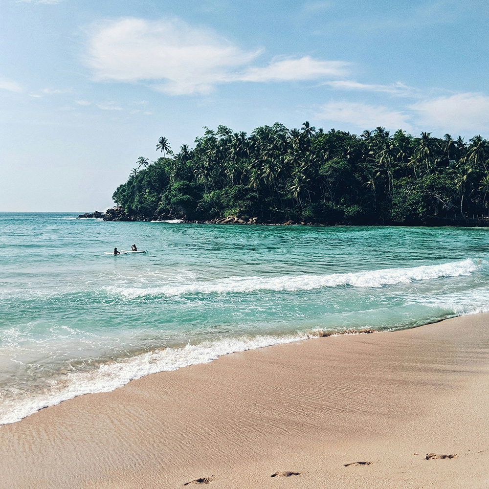 Beach scene in Hiriketiya during February, showing the calm, sunny conditions travellers consider when asking if February is a good month to visit Sri Lanka.