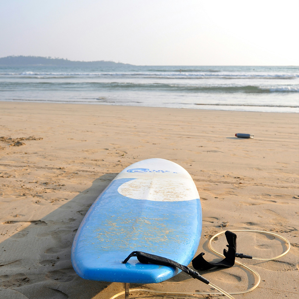 Beach scene in Weligama with a surfboard on the sand during March, showing the warm late‑season conditions travellers consider when asking if March is a good month to visit Sri Lanka.