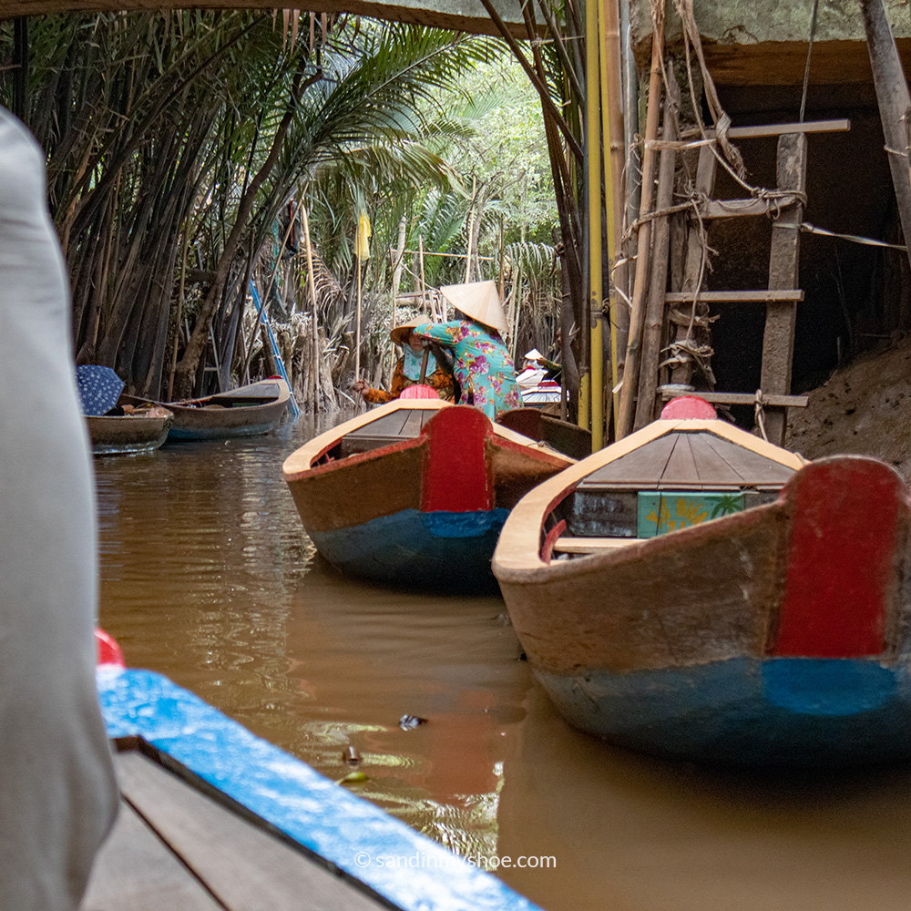 Boats in a canal deep in the Mekong Delta