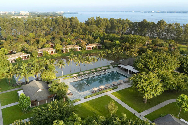 View of Legacy Con Au Resort showing the outdoor pool area, greenery, and surrounding natural landscape.
