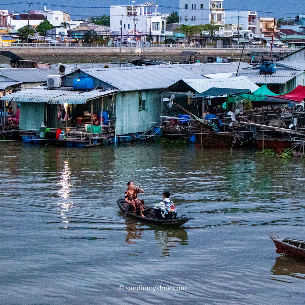 Mother rowing child to school in Can Tho, Mekong Delta, Vietnam