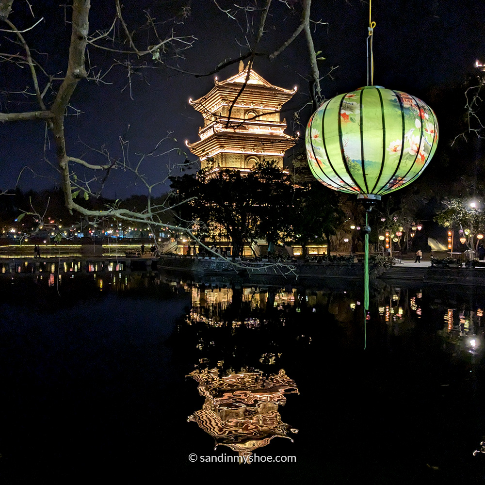 The Perfume River at night with a pagoda mirrored in the water.