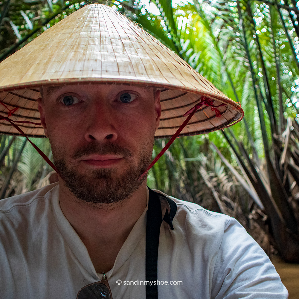 Petteri on Sampan boat tour wearing a typical farmer's hat in Ben Tre, Vietnam