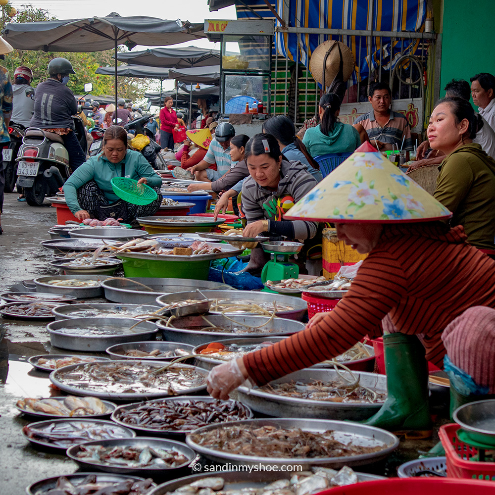 Vendors at the land market, buckets filled with fresh seafood