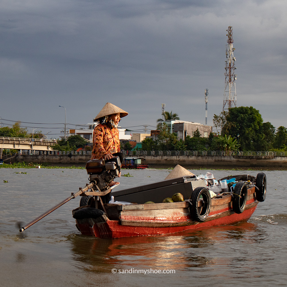 Coconut vendor on a wooden boat scouting for tourists in Can Tho