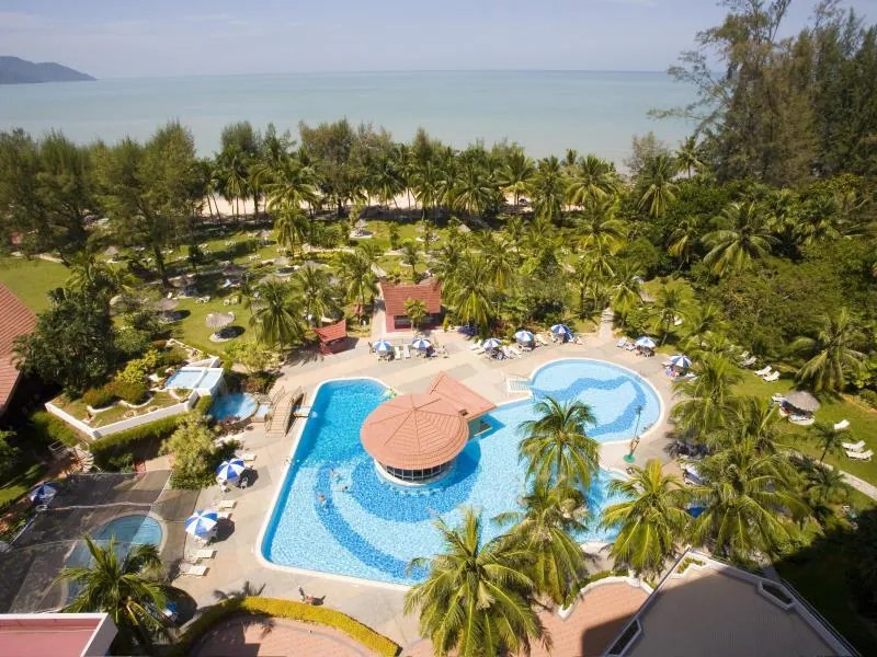 Pool at Bayview Beach Resort with the beach and ocean visible in the background.