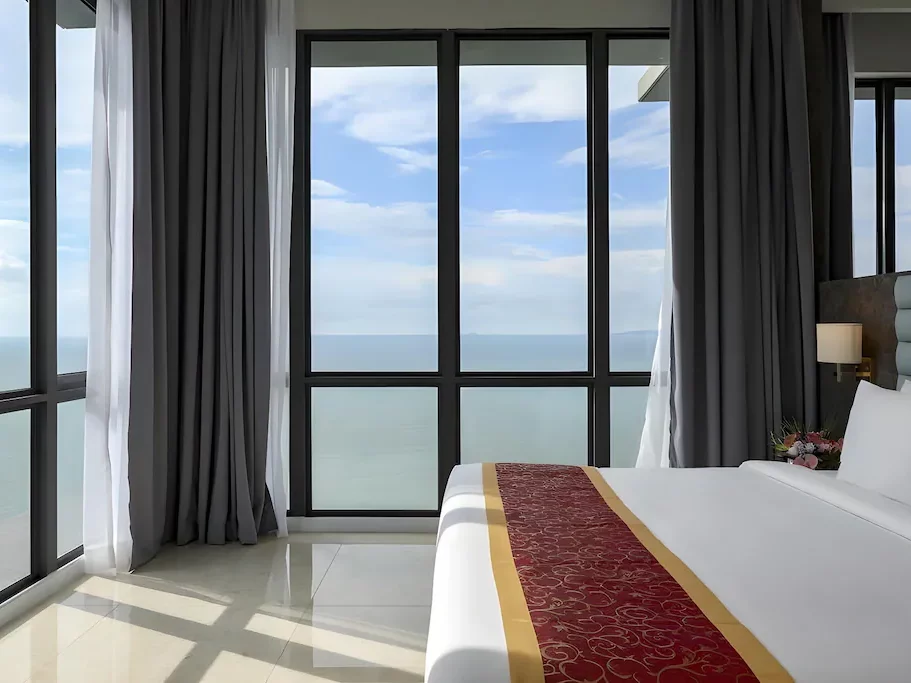 Guest room at Hompton by the Beach Penang featuring large windows with an ocean view.