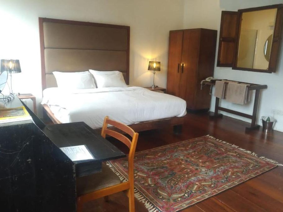 Decent sized heritage‑style room at Ren I Tang Heritage Inn with wooden floors and traditional details.