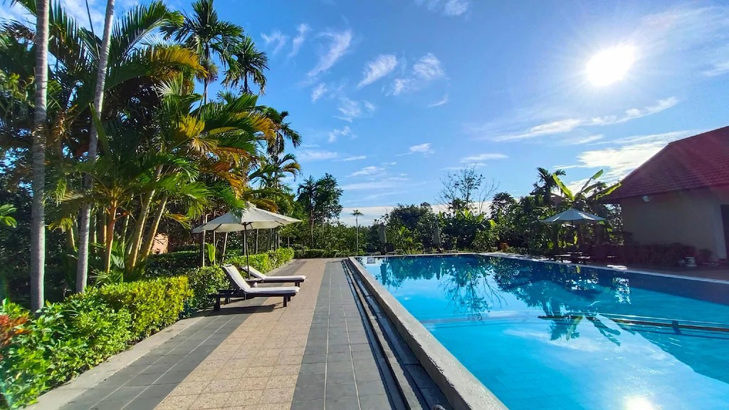 Outdoor pool at Huế Riverside Boutique Resort & Spa surrounded by greenery in the Hue countryside.
