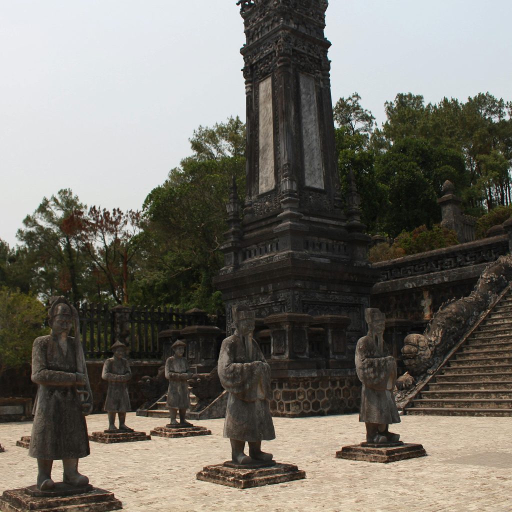 Stone warrior statues at Khải Định Tomb in Huế, arranged in formation within the courtyard.