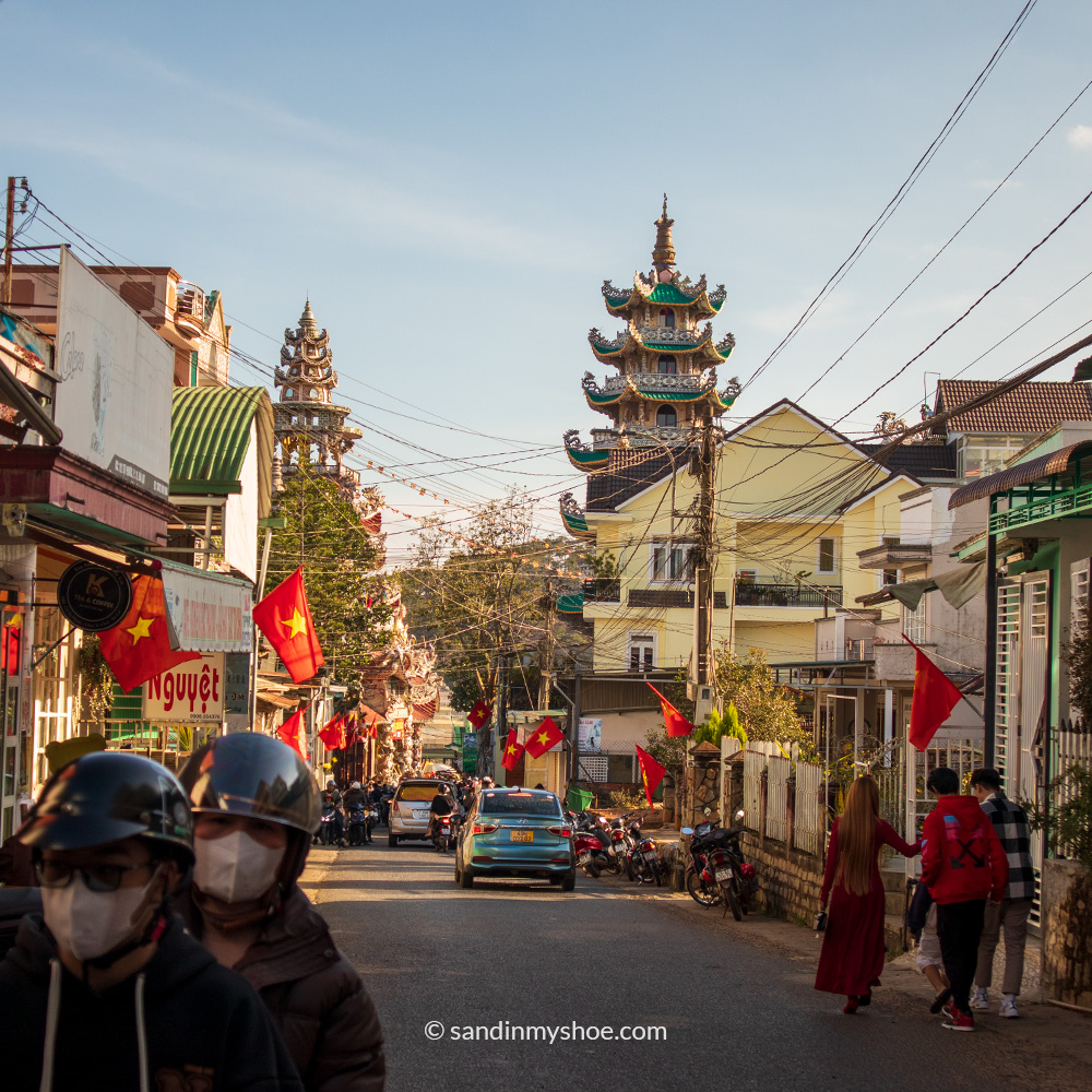 Linh Phuoc Pagoda with a street filled with Vietnamese flags
