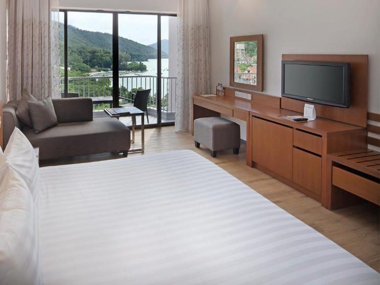 Guest room at Bayview Beach Resort featuring large windows overlooking the ocean.
