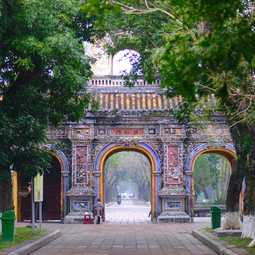 Quiet old port in Hue facing a road lined with trees on both sides, included as a visual reference for where to stay in Hue.