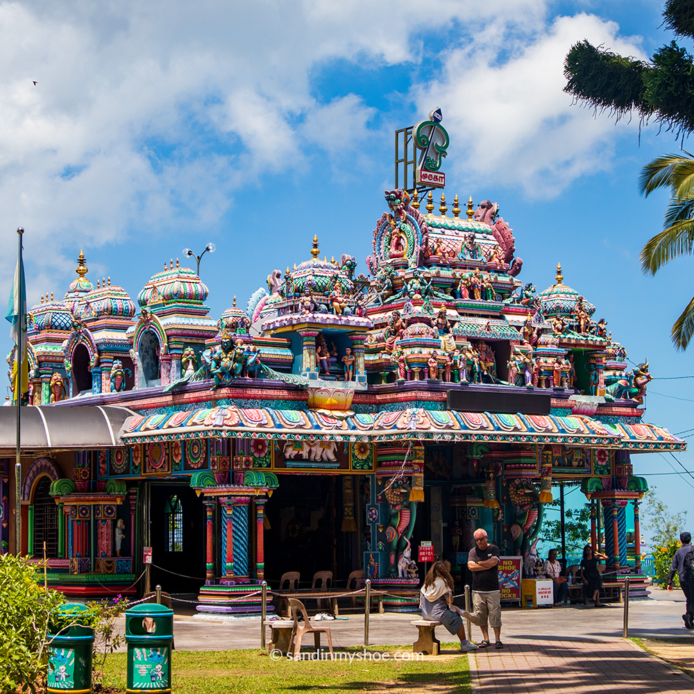 Brightly coloured Hindu temple on Penang Hill with detailed carvings, vivid statues, and an ornate, maximalist design.