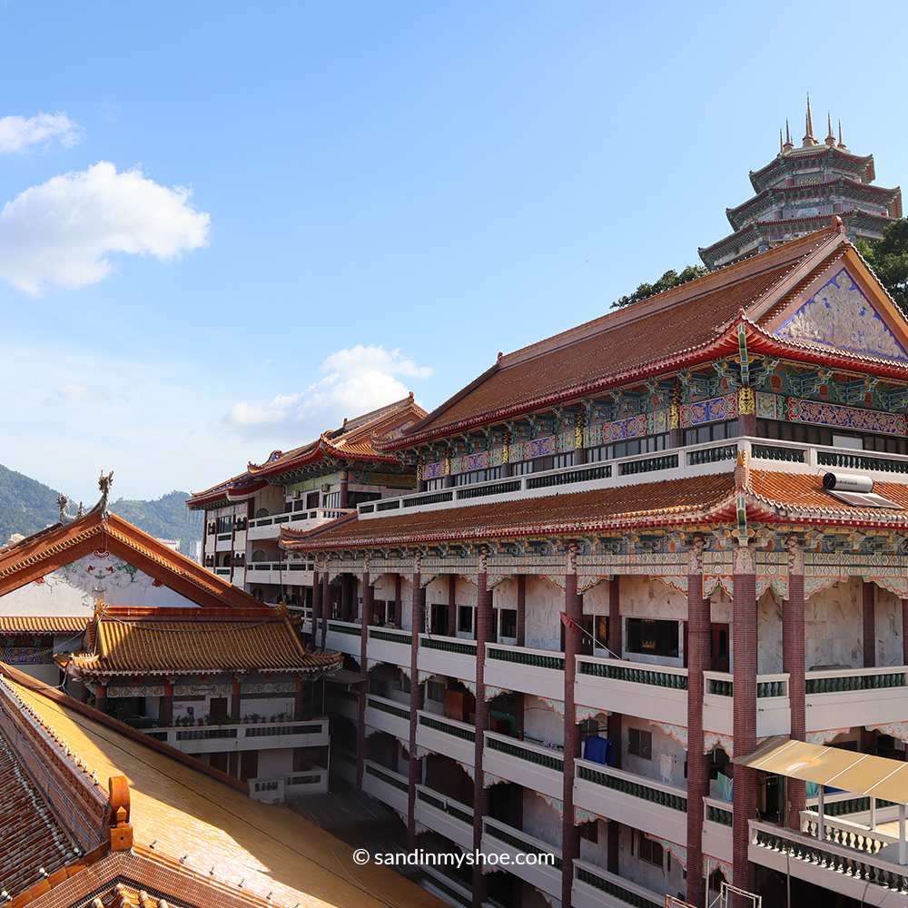 Multiple temple buildings at Kek Lok Si spread across the hillside, with colourful roofs, pagodas, and intricate architectural details.