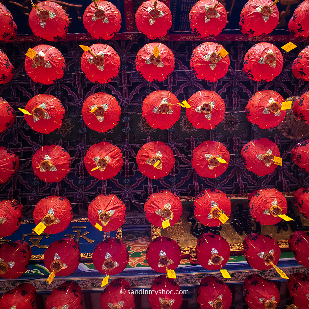 Upward view of hanging lanterns at Kek Lok Si, photographed from beneath, showing rows of colourful lights suspended above.