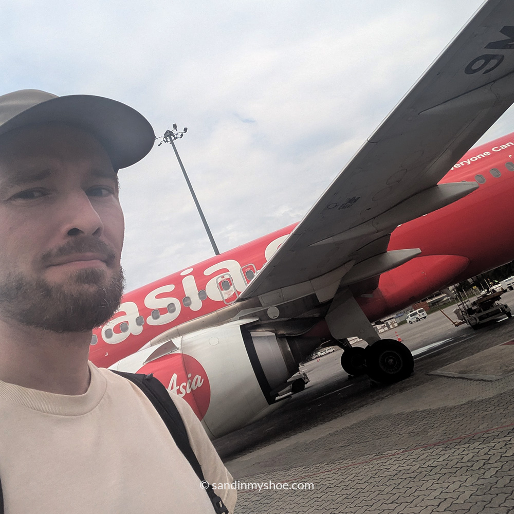 Petteri standing in front of an AirAsia airplane.
