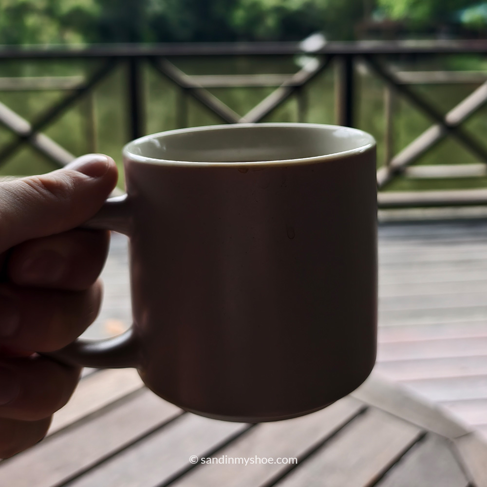 Petteri holding a coffee mug inside Rainforest Discovery Center. 
