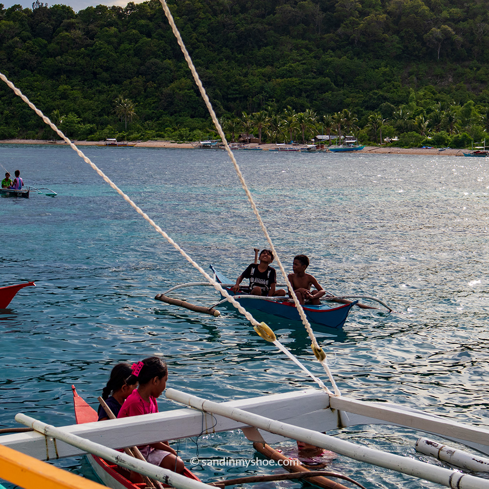 Children on boats on a remote island in Palawan, Philippines
