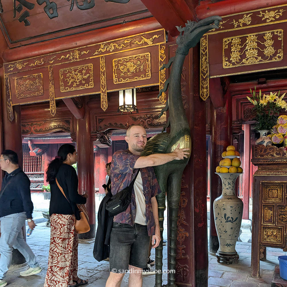 Petteri rubbing a birdlike statue for good luck in the Temple of Literature.