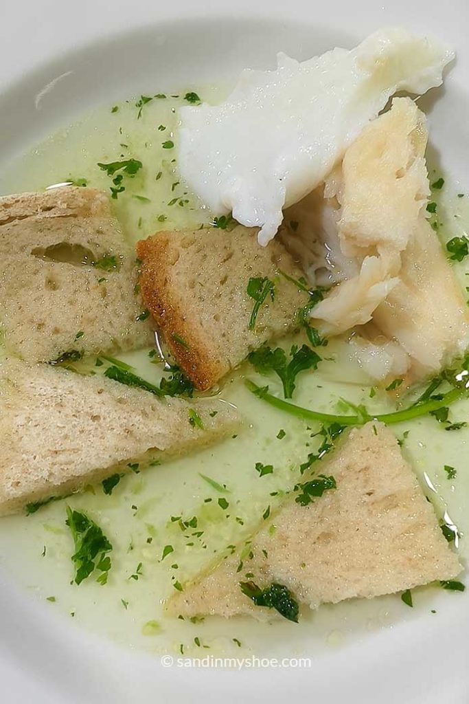 Acorda a alentejana, also known as Prisoner's soup. Made from broth, bread, plenty of cilantro, egg and fish.