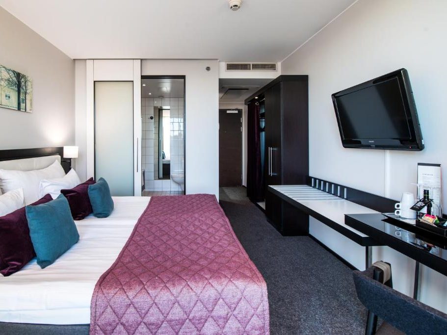 Hotel Clarion’s spacious room with a comfortable bed and modern furnishings.