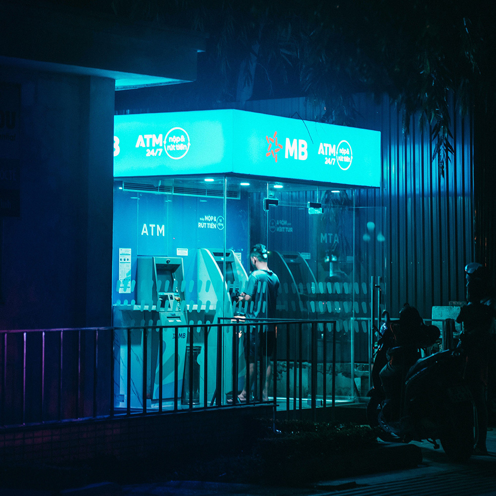 Man taking out money at an MB Bank ATM in Vietnam, a common money‑saving recommendation in travel tips Vietnam.