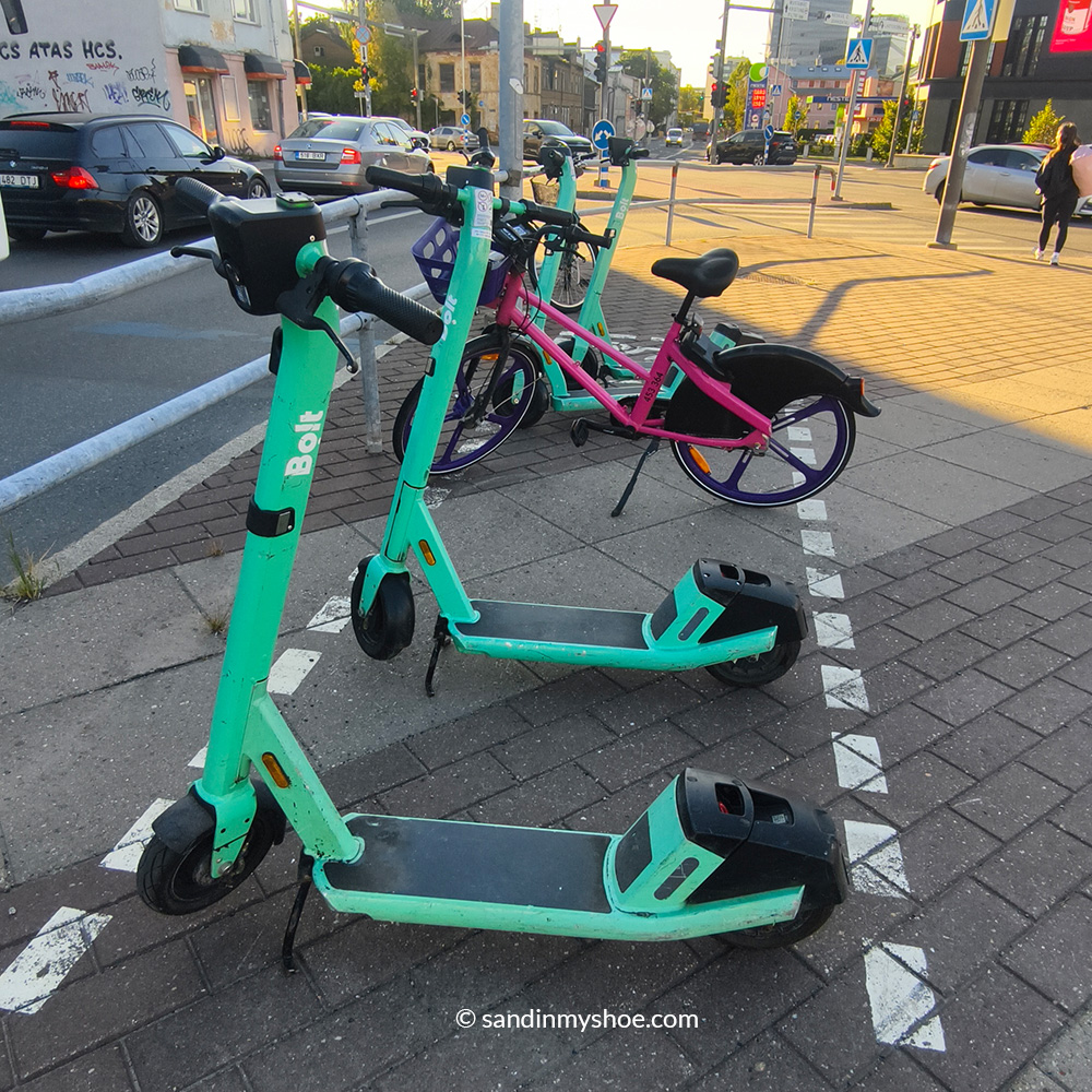 Four Bolt electric scooters parked along the street.