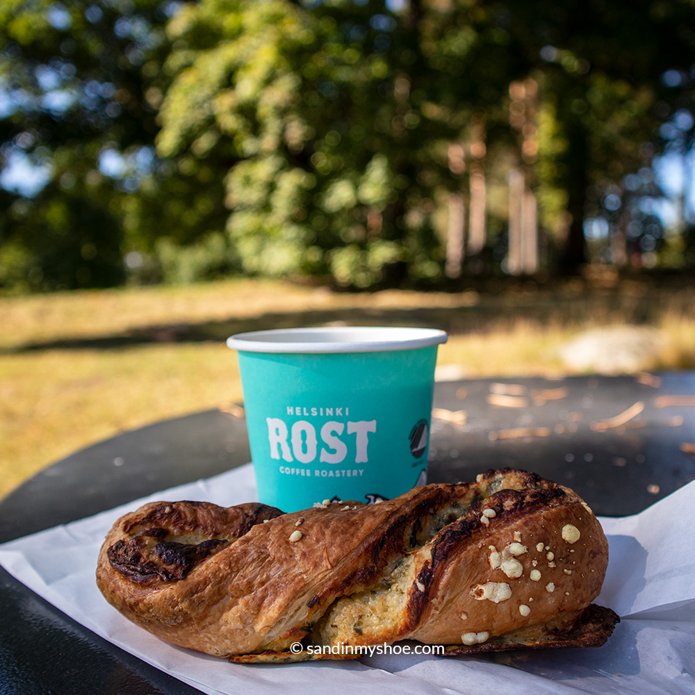 Take away coffee and a pastry eaten at a park.