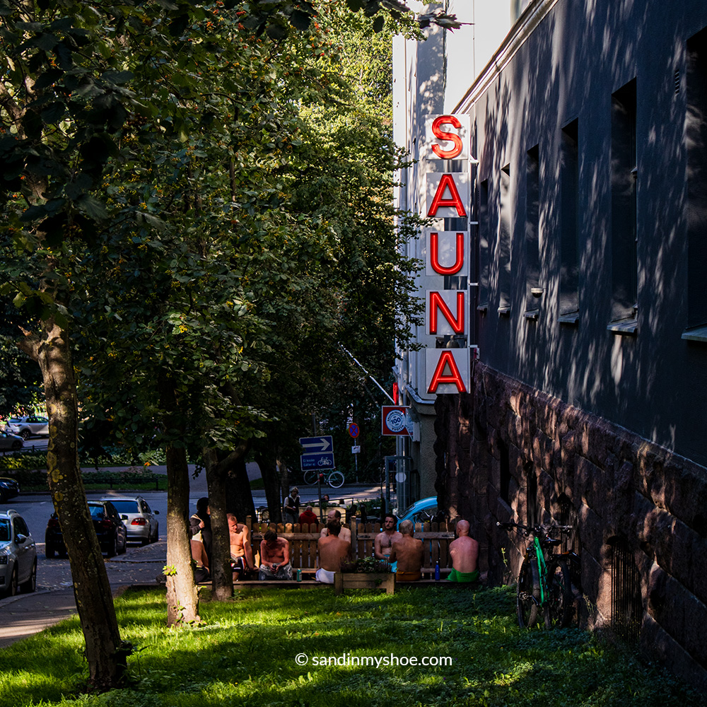 People sitting outside Kotiharjun Sauna and cooling off between sauna sessions.