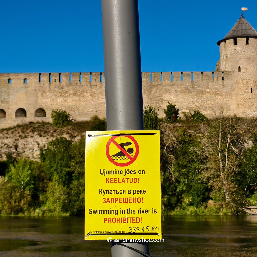 A sign that shows no swimming allowed. The Narva River separates Narva Castle in Estonia from Ivangorod Castle in Russia.